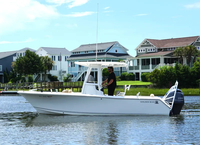 The Image of 2016 Sea Hunt Ultra 225 boat on water near coastal homes, clear sky. - 1