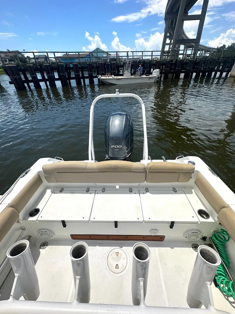 Slide: The Image of 2016 Sea Hunt Ultra 225 boat with Yamaha 200 engine, docked near a bridge. - 10