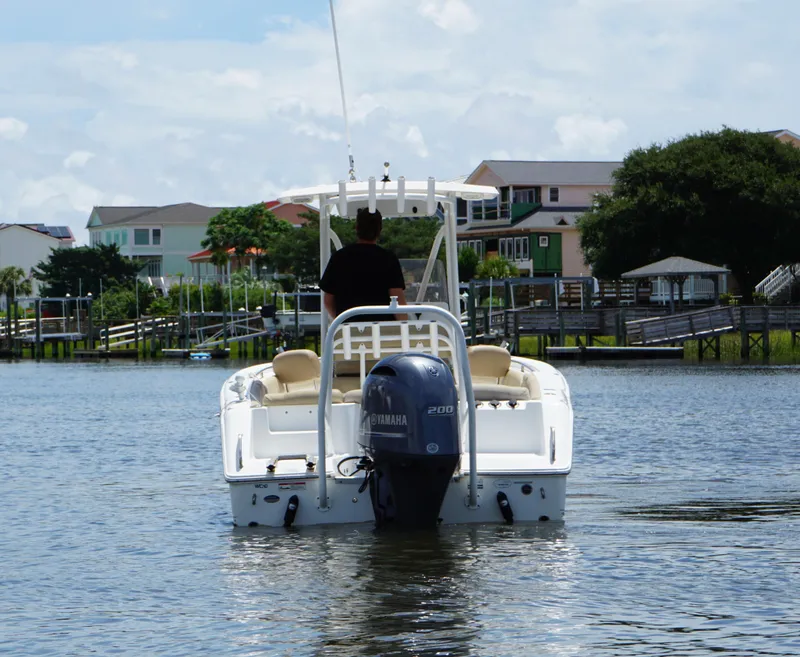 Slide: The Image of 2016 Sea Hunt Ultra 225 boat on water, Yamaha engine, residential backdrop. - 3