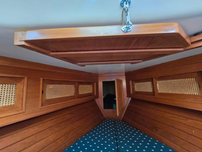 Slide: The Image of Interior of 1984 Bristol 31.1 sailboat with wooden paneling and polka dot bedding. - 10