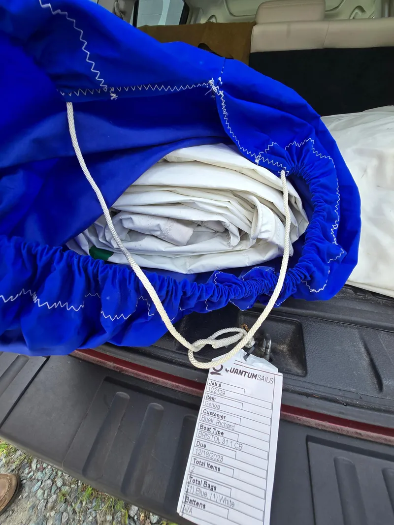 Slide: The Image of Bag of sails in a blue cover with a tag, in a vehicle trunk. - 17