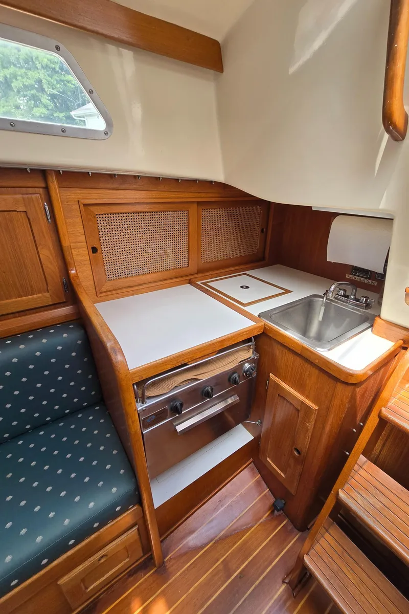 Slide: The Image of 1984 Bristol 31.1 yacht interior kitchen with wood cabinetry, stove, and sink. - 21