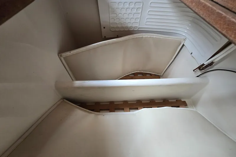 Slide: The Image of Interior of a 1984 Bristol 31.1 sailboat, featuring white panels and wooden slats. - 24