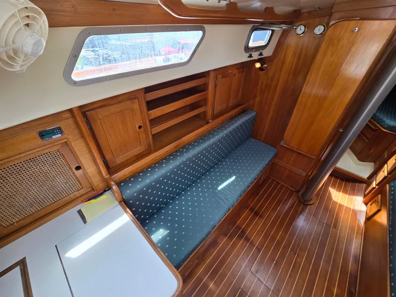 Slide: The Image of 1984 Bristol 31.1 yacht interior with wooden finish and blue cushioned seating. - 3