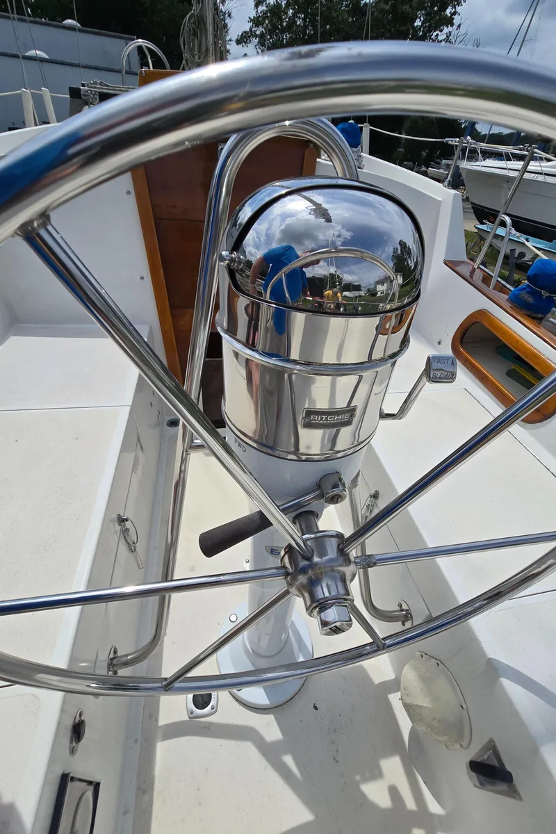 Slide: The Image of Steering wheel of a 1984 Bristol 31.1 sailboat with a polished metal compass. - 42