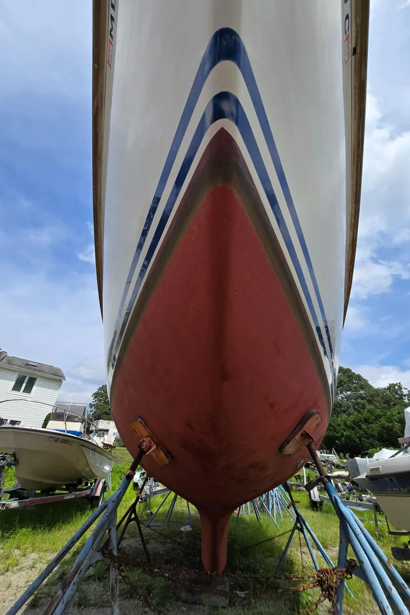 Slide: The Image of 1984 Bristol 31.1 sailboat on stands, viewed from below, with blue sky background. - 45