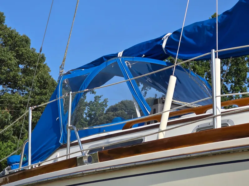 Slide: The Image of 1984 Bristol 31.1 Keel centerboard sailboat with blue canopy and clear skies. - 47