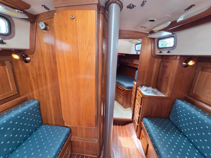 Slide: The Image of 1984 Bristol 31.1 yacht interior with wood paneling and blue cushioned seating. - 6