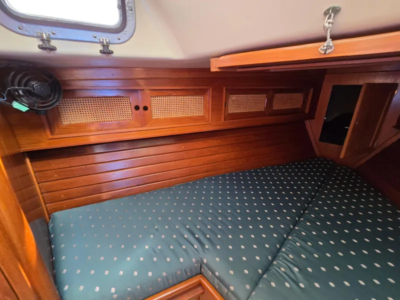 Slide: The Image of Cozy cabin interior of 1984 Bristol 31.1 sailboat with wooden paneling and cushioned bed. - 9