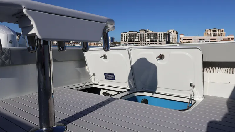 Slide: The Image of Freeman 47 boat deck with open storage compartments, city skyline in background, 2021 model. - 19