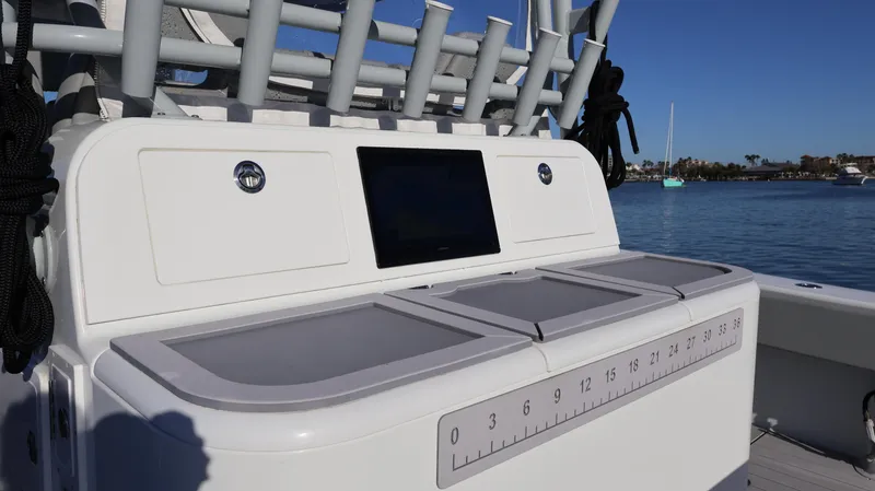 Slide: The Image of 2021 Freeman 47 boat console with storage compartments and ruler, docked by the water. - 22