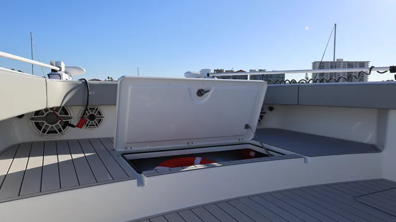 Slide: The Image of Open storage compartment on 2021 Freeman 47 boat deck with speakers and city skyline. - 28