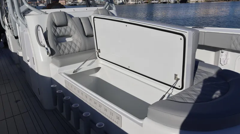 Slide: The Image of Open storage compartment on a 2021 Freeman 47 boat, with cushioned seating and rod holders. - 33
