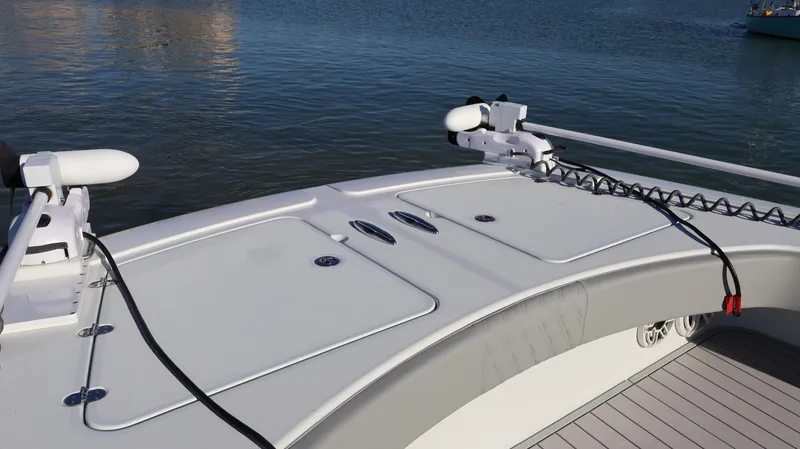 Slide: The Image of 2021 Freeman 47 boat deck with storage compartments and fishing equipment, on calm water. - 40