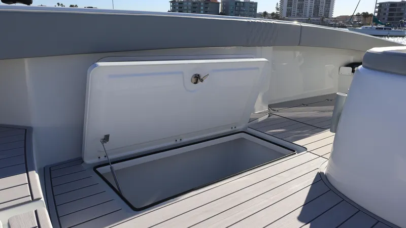 Slide: The Image of Open storage compartment on 2021 Freeman 47 boat deck, with cityscape in background. - 42
