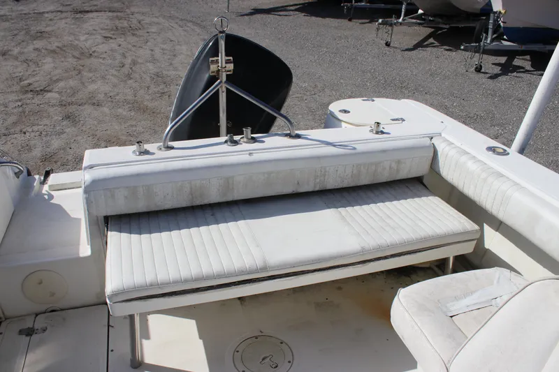 Slide: The Image of 2004 Boston Whaler 210 Ventura boat interior with white seating and storage. - 10