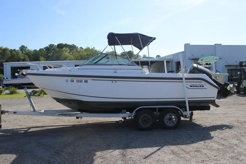 Slide: The Image of 2004 Boston Whaler 210 Ventura boat on trailer, parked outdoors. - 2