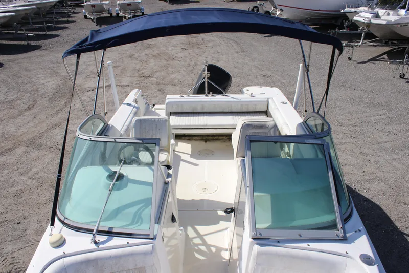 Slide: The Image of 2004 Boston Whaler 210 Ventura boat with blue canopy, parked on gravel. - 3