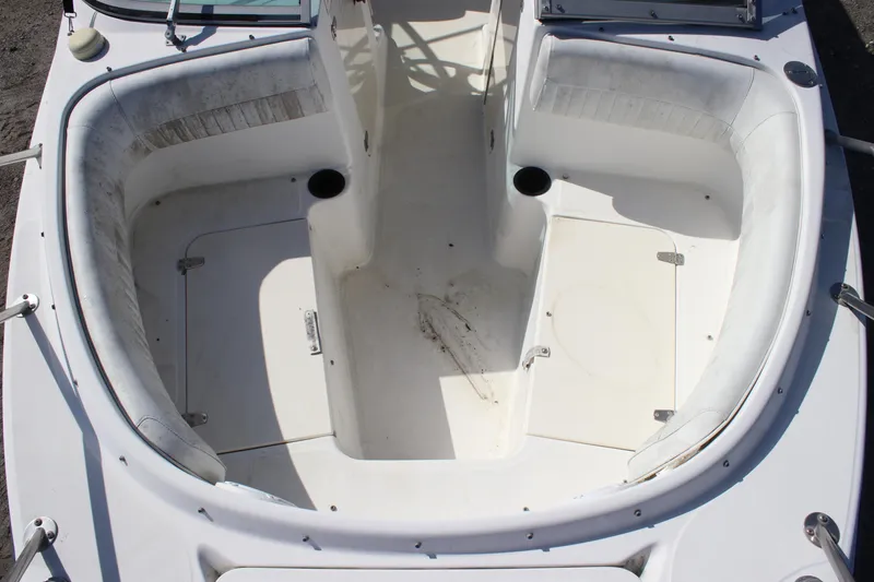 Slide: The Image of 2004 Boston Whaler 210 Ventura boat interior with white seating and storage compartments. - 4