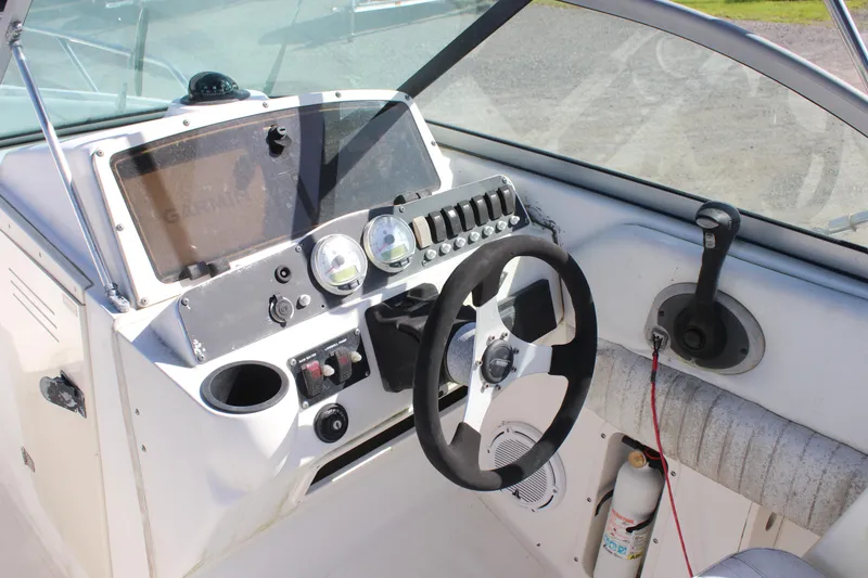 Slide: The Image of 2004 Boston Whaler 210 Ventura boat dashboard with steering wheel and control panel. - 8