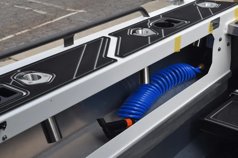 Slide: The Image of 2026 Stabicraft 1850 Supercab Sportfish interior with cup holders and blue coiled hose. - 15