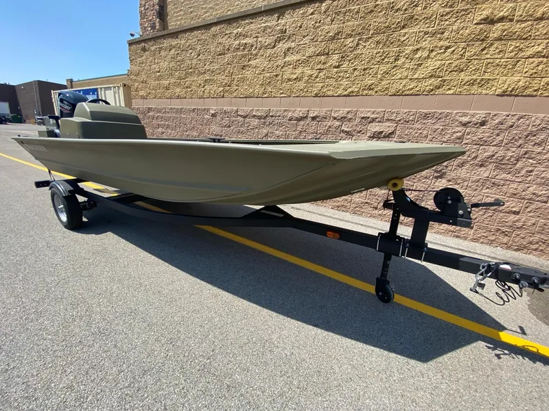 Slide: The Image of 2024 Tracker Grizzly 1648 SC boat on trailer, parked outdoors. - 2