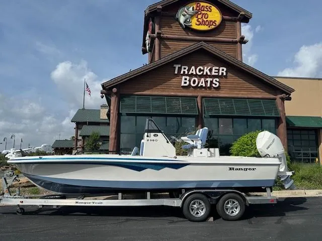 The Image of 2025 Ranger 2360 Bay boat on trailer outside Bass Pro Shops Tracker Boats store. - 0