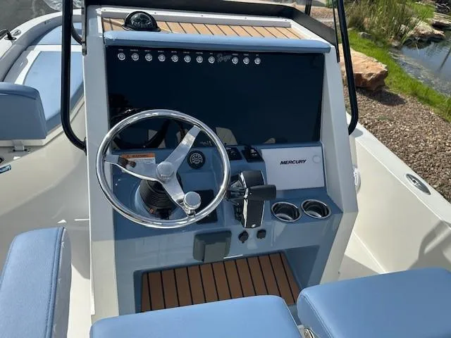 Slide: The Image of 2025 Ranger 2360 Bay boat dashboard with steering wheel and Mercury controls. - 10