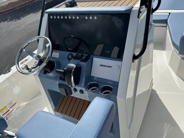 Slide: The Image of 2025 Ranger 2360 Bay boat console with steering wheel and Mercury controls. - 11