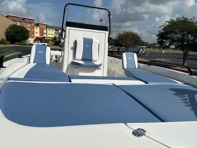 Slide: The Image of 2025 Ranger 2360 Bay boat with blue and white seating, parked outdoors under a cloudy sky. - 6