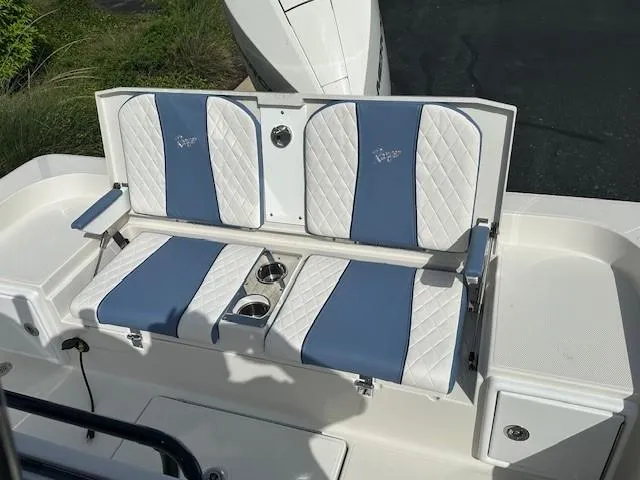 Slide: The Image of 2025 Ranger 2360 Bay boat seating with blue and white cushioned design and cup holders. - 7