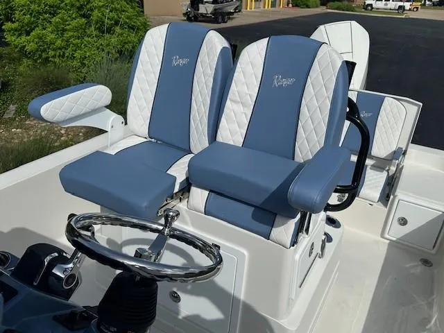 Slide: The Image of 2025 Ranger 2360 Bay boat seats with blue and white upholstery, featuring a sleek steering wheel. - 9