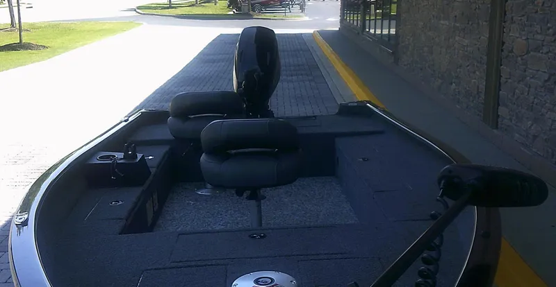 Slide: The Image of 2025 Tracker Super Guide V-16 T boat with seating and storage, parked on a paved driveway. - 4