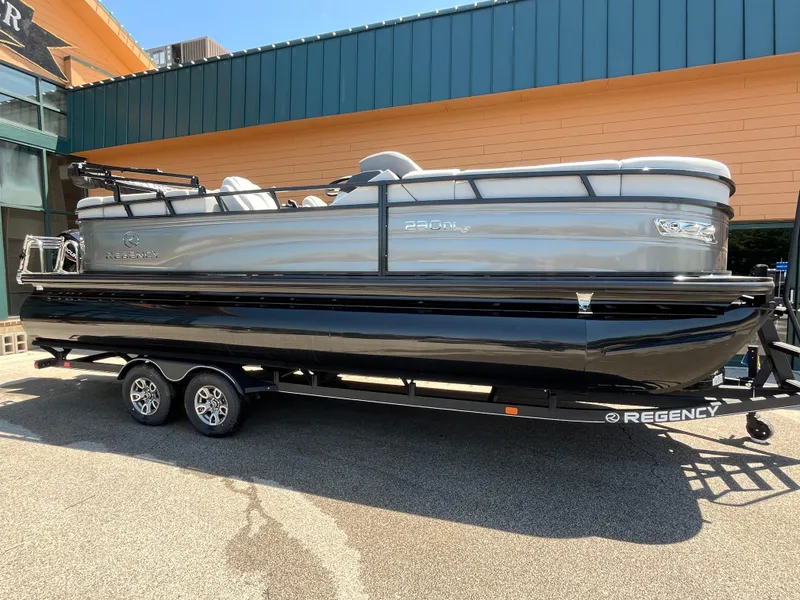 The Image of 2025 Regency 230 DL3 pontoon boat on trailer, displayed outdoors. - 0