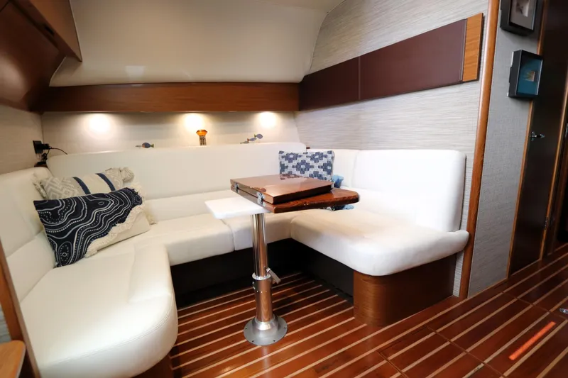 Slide: The Image of Luxurious interior of 2020 Tiara Yachts 43 Open with white seating and wooden accents. - 10