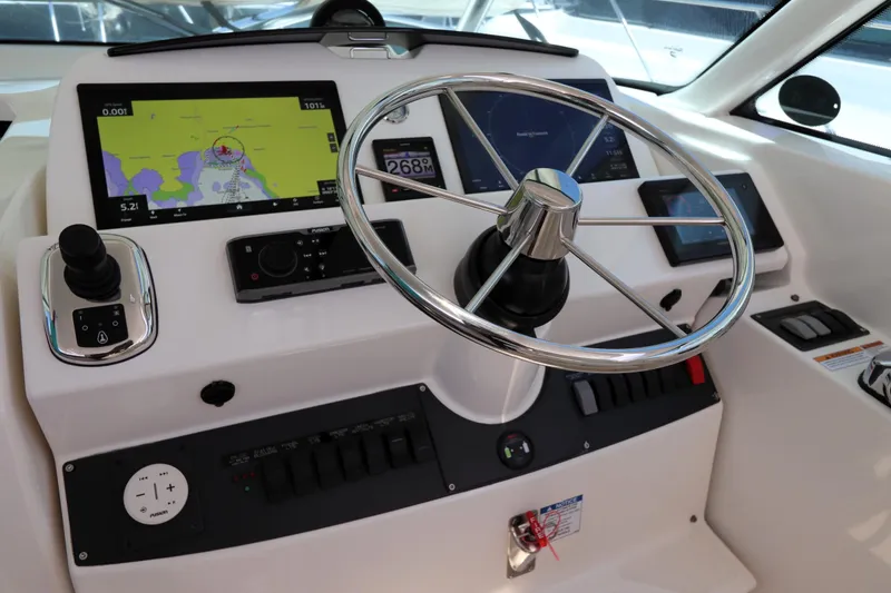 Slide: The Image of 2020 Tiara Yachts 43 Open helm with navigation screens and steering wheel. - 3