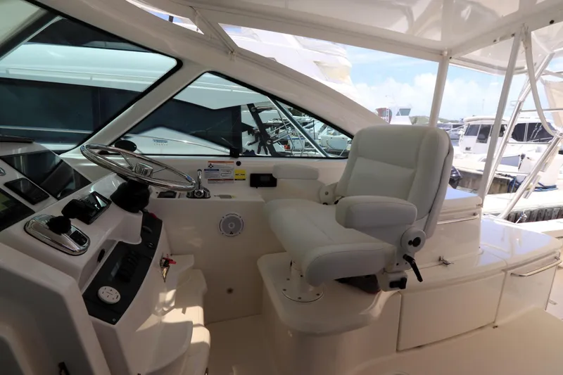 Slide: The Image of 2020 Tiara Yachts 43 Open helm with white captain's chair and steering wheel. - 5