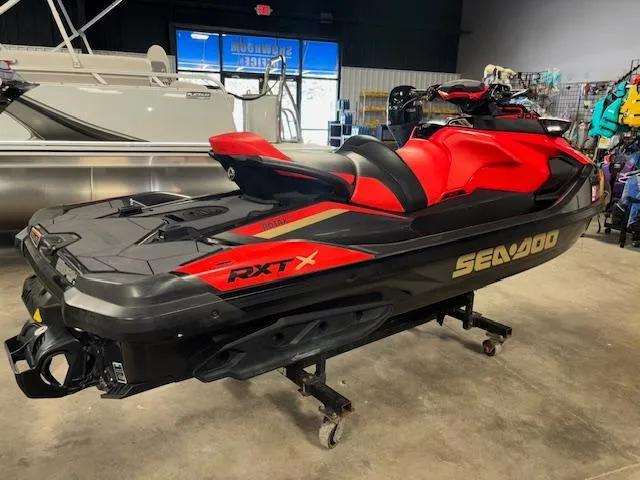 Slide: The Image of 2019 Sea-Doo RXTX jet ski in showroom, red and black design, side view. - 11