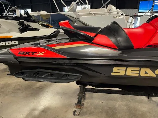 Slide: The Image of 2019 Sea-Doo RXTX jet ski in showroom, featuring sleek red and black design. - 13