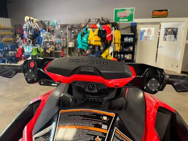 Slide: The Image of 2019 Sea-Doo RXTX handlebars in a showroom with colorful gear in the background. - 16