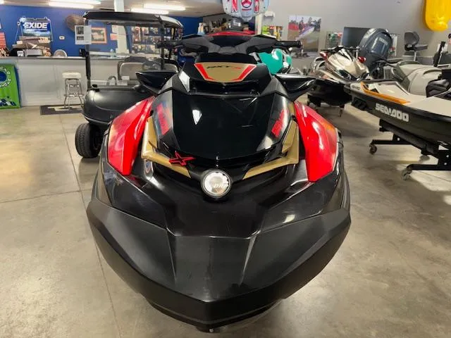 Slide: The Image of 2019 Sea-Doo RXTX jet ski in showroom, front view with vibrant red and black design. - 3