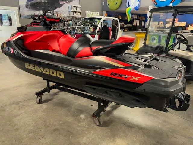 Slide: The Image of 2019 Sea-Doo RXTX jet ski in showroom, red and black design, side view. - 7