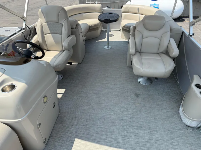 Slide: The Image of Interior of 2016 South Bay 521RS pontoon boat with beige seating and steering console. - 11