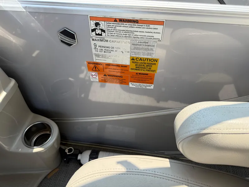 Slide: The Image of 2016 South Bay 521RS boat interior with safety warning labels and cup holder. - 16