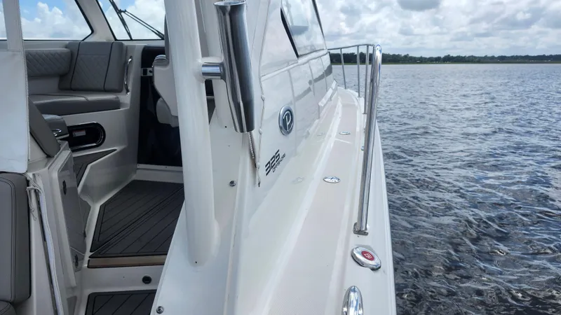 Slide: The Image of 2023 Pursuit OS 325 Offshore boat on water, showcasing sleek design and interior seating. - 10