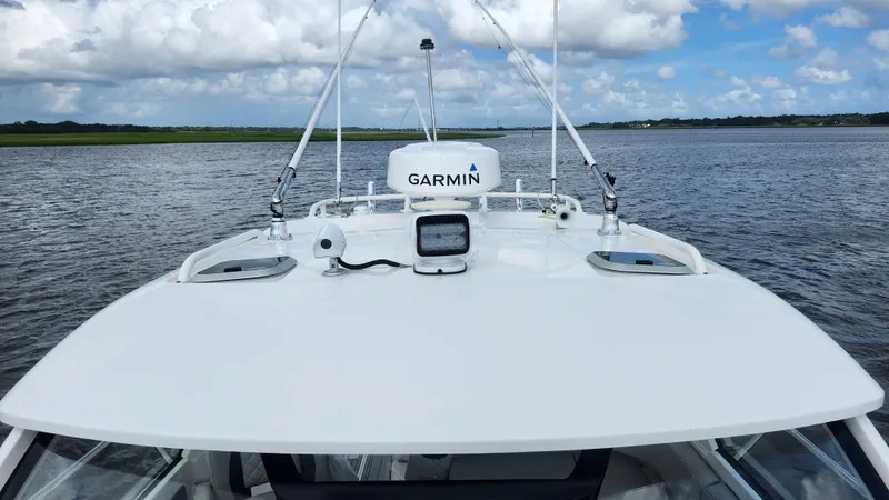 Slide: The Image of 2023 Pursuit OS 325 Offshore boat with Garmin equipment on open water. - 11