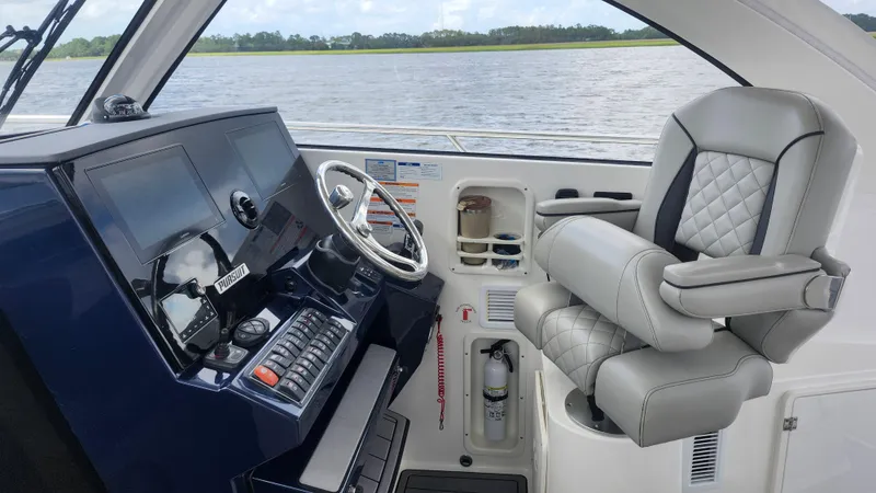 Slide: The Image of 2023 Pursuit OS 325 Offshore helm with modern controls and luxurious seating. - 15