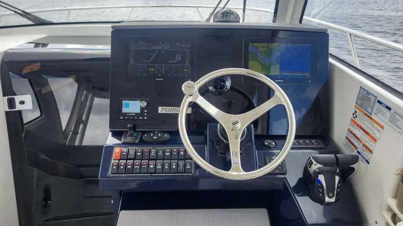 Slide: The Image of 2023 Pursuit OS 325 Offshore helm with modern navigation displays and controls. - 16