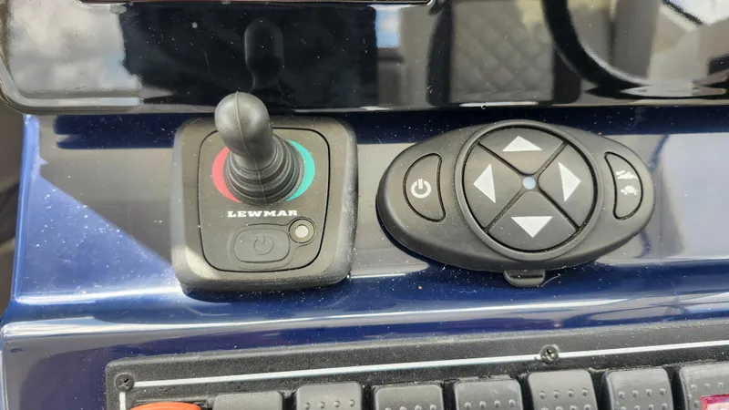 Slide: The Image of Control panel of 2023 Pursuit OS 325 Offshore boat with joystick and button interface. - 17