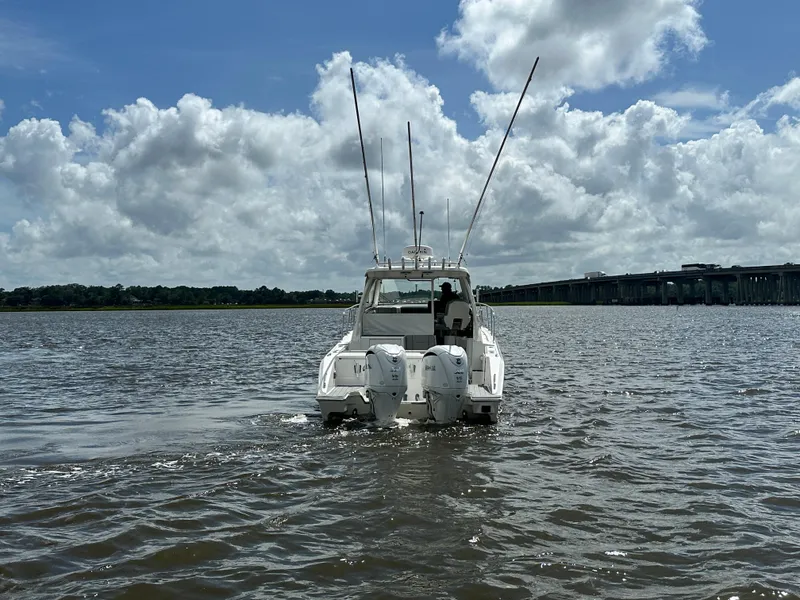 Slide: The Image of 2023 Pursuit OS 325 Offshore boat on water under cloudy sky. - 2